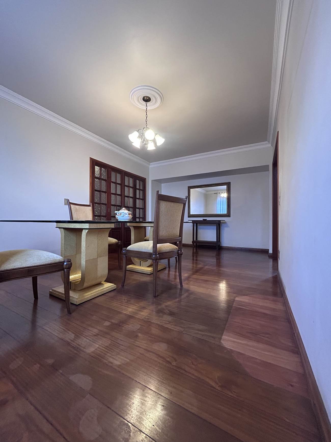 Sala de jantar integrada, com porta de madeira trabalhada